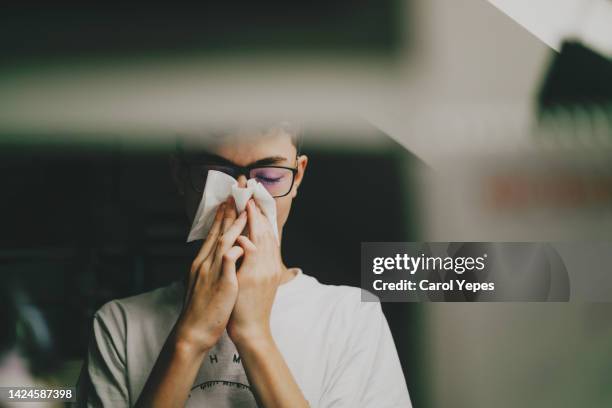 boy wiping runny nose with a tissue - verkoudheid en griep stockfoto's en -beelden