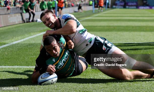 Juarno Augustus of Northampton Saints dives over for the first try despite being held by Ben Donnell during the Gallagher Premiership Rugby match...