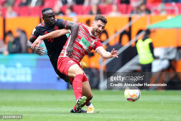 Maximilian Bauer of FC Augsburg battles for possession with Sadio Mane of Bayern Munich during the Bundesliga match between FC Augsburg and FC Bayern...