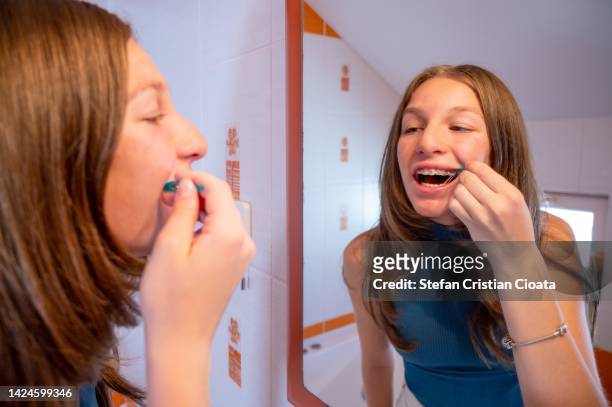 teenager girl putting elastics bands over dental brackets - human mouth stock photos et images de collection