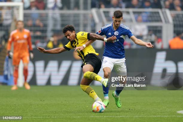 Donyell Malen of Borussia Dortmund battles for possession with Tom Kraub of FC Schalke 04 during the Bundesliga match between Borussia Dortmund and...