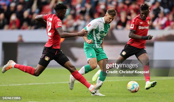 Niclas Fullkrug of Werder Bremen is put under pressure by Edmond Tapsoba and Odilon Kossounou of Bayer Leverkusen during the Bundesliga match between...