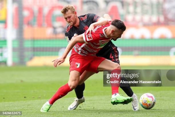 Mergim Berisha of FC Augsburg challenges for the ball with Matthijs de Ligt of Bayern Munich during the Bundesliga match between FC Augsburg and FC...