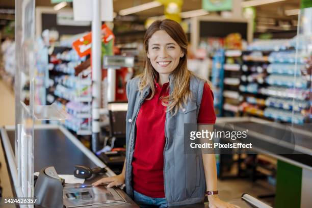 portrait of smiling female cashier - serbia supermarket stock pictures, royalty-free photos & images