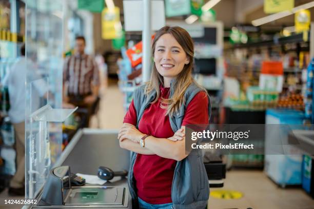 smiling female cashier looking at camera - saleswoman stock pictures, royalty-free photos & images
