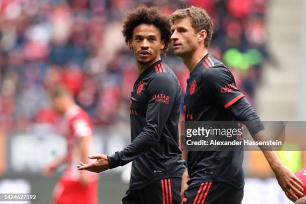 Leroy Sane of Bayern Munich talks to his team mate Thomas Müller during the Bundesliga match between FC Augsburg and FC Bayern München at WWK-Arena...
