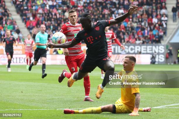 Sadio Mane of Bayern Munich battles for the ball with Rafal Gikiewicz, keeper of FC Augsburg during the Bundesliga match between FC Augsburg and FC...
