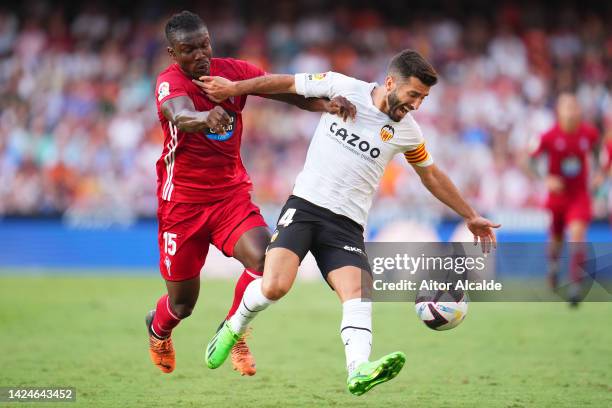 Yunus Musah of Valencia CF is challenged by Joseph Aidoo of RC Celta during the LaLiga Santander match between Valencia CF and RC Celta at Estadio...