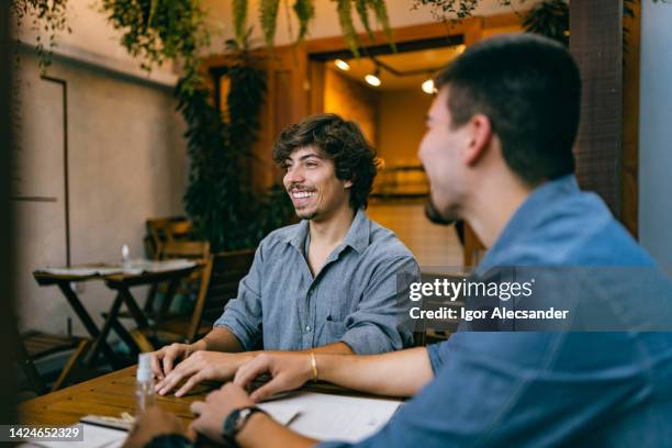 lächelnde freunde vor der bestellung im café - prämienkarte stock-fotos und bilder