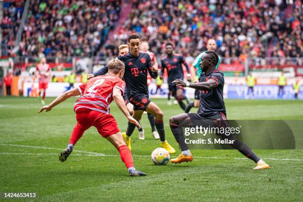 Sadio Mane of FC Bayern Muenchen and Jamal Musiala of FC Bayern Muenchen are challenged during the Bundesliga match between FC Augsburg and FC Bayern...