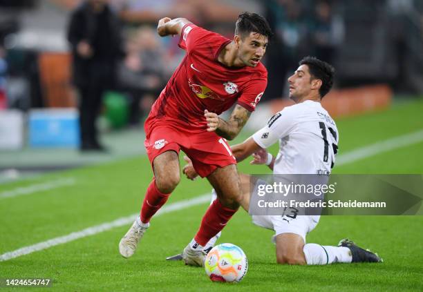 Dominik Szoboszlai of RB Leipzig is challenged by Lars Stindl of Borussia Monchengladbach during the Bundesliga match between Borussia...