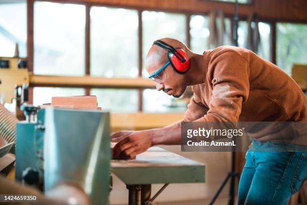 Focused Mid Adult Man Using Cutting Machine for Wood