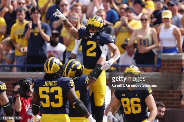 Blake Corum of the Michigan Wolverines celebrates a first half touchdown with his teammates while playing the Connecticut Huskies at Michigan Stadium...