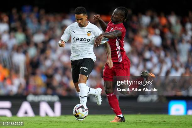 Justin Kluivert of Valencia is challenged by Joseph Aidoo of Celta during the LaLiga Santander match between Valencia CF and RC Celta at Estadio...