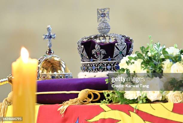 The coffin carrying Queen Elizabeth II is draped in the Royal Standard and adorned with the Imperial State Crown and the Sovereign's orb and sceptre,...