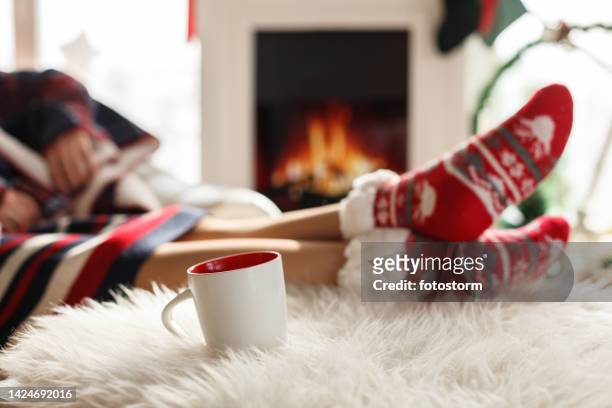 cheminée confortable, chaussettes chaudes sur le thème de noël et une boisson chaude - chaussette noel cheminée photos et images de collection