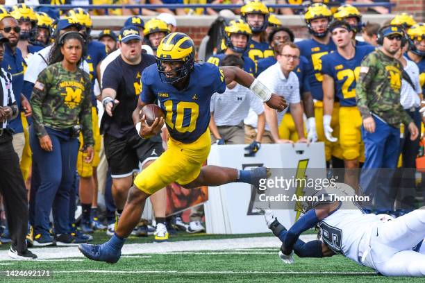 Alex Orji of the Michigan Wolverines avoids a tackle by Durante Jones of the Connecticut Huskies during the second half of a college football game at...
