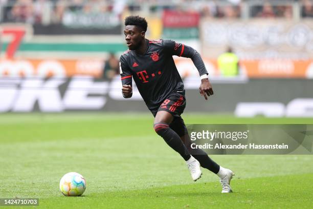 Alphonso Davies of Bayern Munich runs with the ball during the Bundesliga match between FC Augsburg and FC Bayern München at WWK-Arena on September...