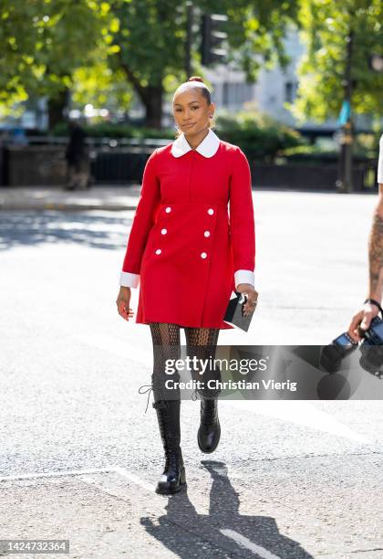 Temi Otedola wears red dress, tights, knee high boots outside Paul & Joe during London Fashion Week September 2022 on September 17, 2022 in London,...