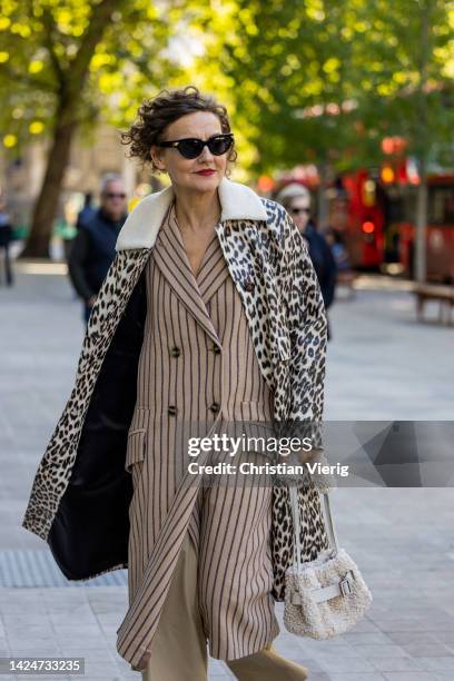 Guest wears coat with animal print, striped coat, teddy bag outside Huishan Zhang during London Fashion Week September 2022 on September 17, 2022 in...