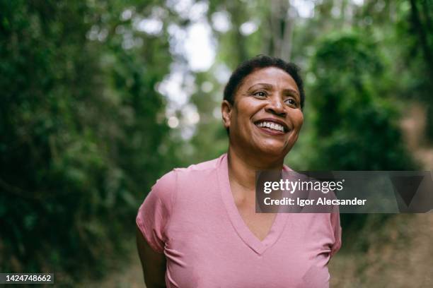 donna matura che contempla la natura - donne mature foto e immagini stock