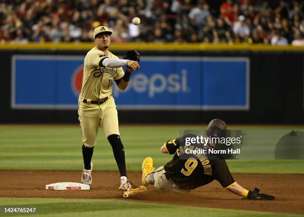 Josh Rojas of the Arizona Diamondbacks turns a double play on a ground ball hit by Josh Bell of the San Diego Padres as Jake Cronenworth is forced...