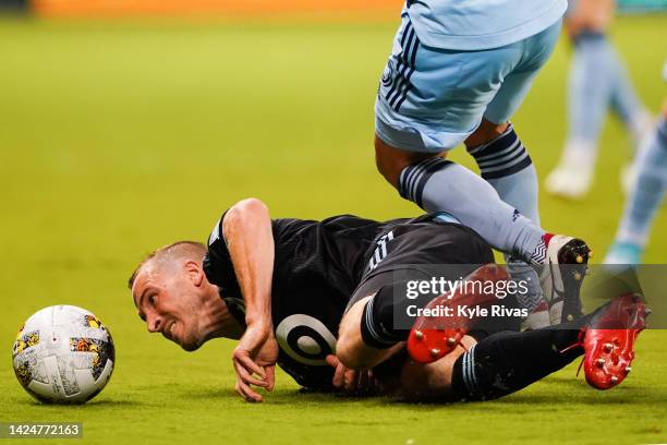 Brent Kallman of Minnesota United is knocked to the ground by Roger Espinoza of Sporting Kansas City during the second half at Children's Mercy Park...