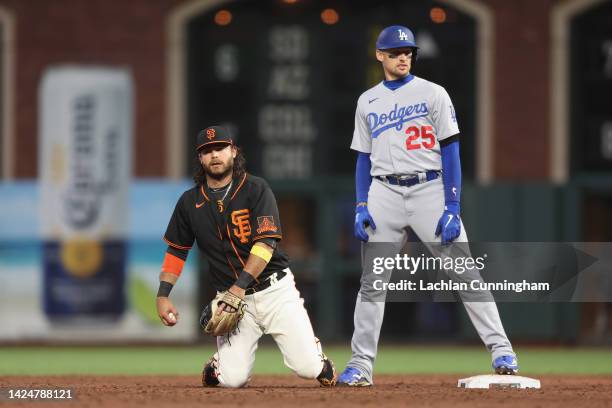 Brandon Crawford of the San Francisco Giants reacts after fumbling the ball before getting the force out at second base of Trayce Thompson of the Los...