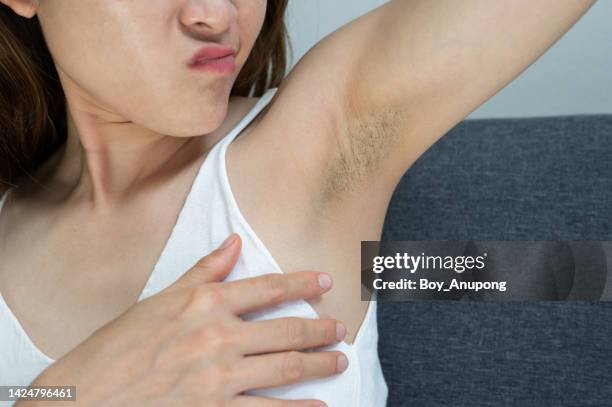 cropped shot of asian woman showing her unshaved armpit. - oksel stockfoto's en -beelden