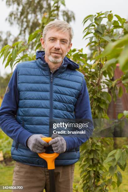 homme blanc de 50 ans travaillant dans son jardin - 50 year old photos et images de collection