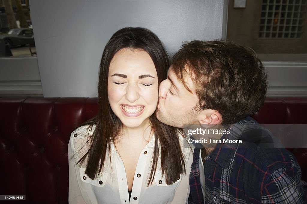 Man kissing woman on cheek