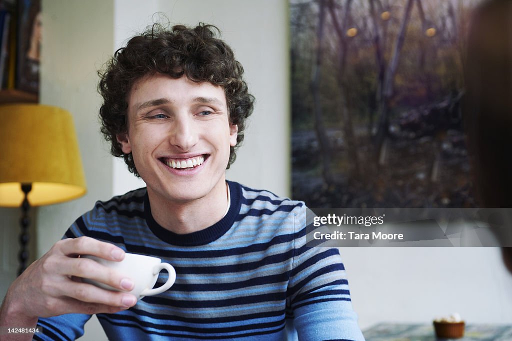 Man smiling with coffee cup in cafe