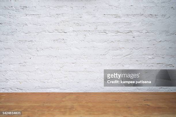 wood table top with white brick wall - table brick wall wood stock-fotos und bilder