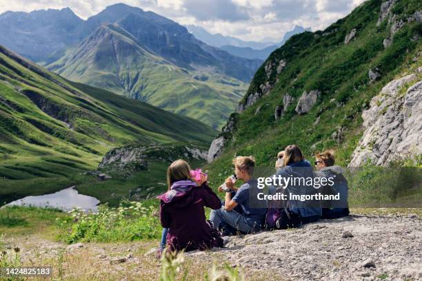 family hiking in the high austrian mountains - alps, tyrol, austria. - oostenrijk stockfoto's en -beelden