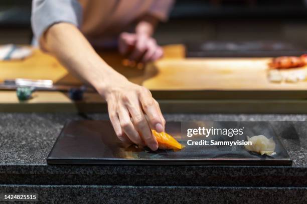 close-up of chef putting sushi on the plate - sushi restaurant 個照片及圖片檔