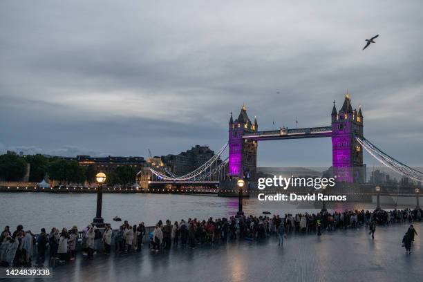 Members of the public, wrapped in blankets, walk in line along The Queens Walk near Tower Bridge waiting to pay their respects to Queen Elizabeth II...