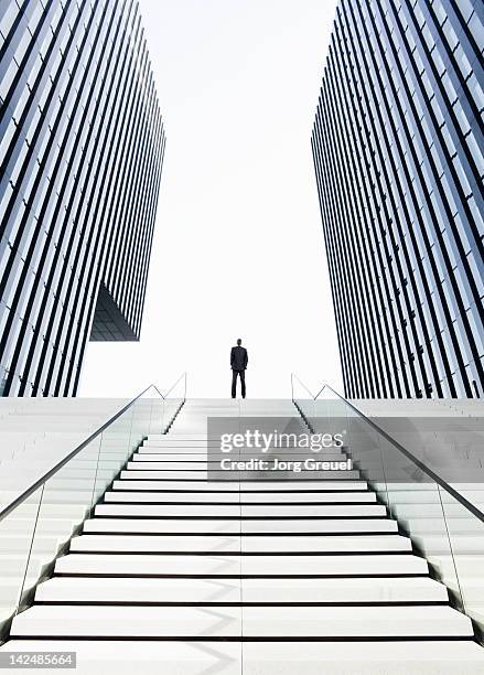 man standing on top of stairs - effet de perspective photos et images de collection