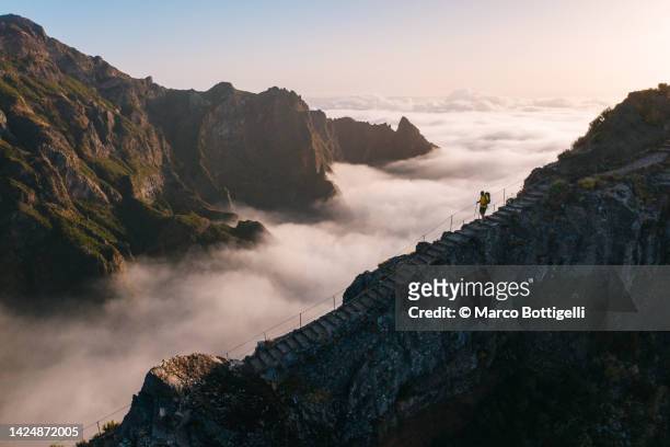 person hiking on a scenic footpath on mountain ridge - pico ruivo stock pictures, royalty-free photos & images