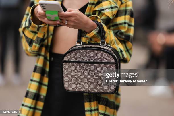 Guest seen wearing a shirt jacket and a coach bag, outside coach during new york fashion week on September 12, 2022 in New York City.