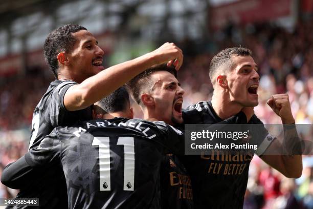 Fabio Viera of Arsenal celebrates with teammates Granit Xhaka and William Saliba after scoring their side's third goal during the Premier League...