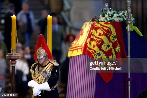 Captain of the Household Cavalry, Blues and Royals stands guard where Queen Elizabeth II's flag-draped coffin is lying in state on the catafalque at...