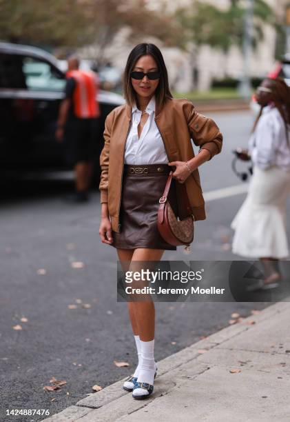Aimee Song seen wearing a leather skirt and a leather jacket in brown shades, outside coach during new york fashion week on September 12, 2022 in New...