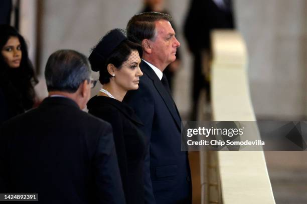 President Jair Bolsonaro of Brazil and his wife Michelle Bolsonaro pay their respects to Queen Elizabeth II's flag-draped coffin lying in state on...