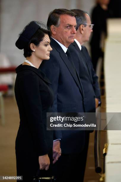 President Jair Bolsonaro of Brazil and his wife Michelle Bolsonaro pay their respects to Queen Elizabeth II's flag-draped coffin lying in state on...