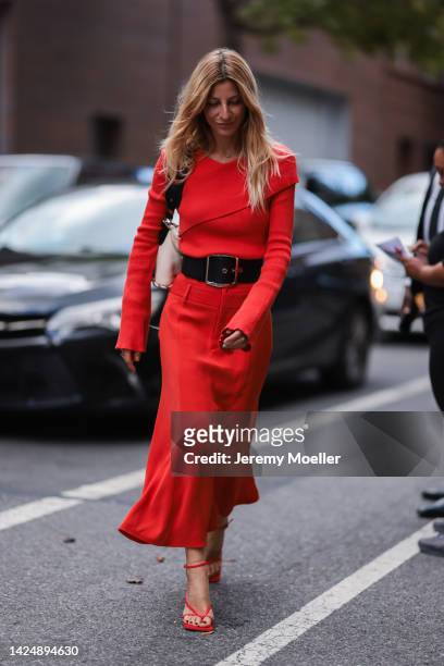 Ada Kokosar is seen wearing a red sweater, black leather large belt, red long skirt, a beige/black shoulder bag and red heels, outside Jonathan...