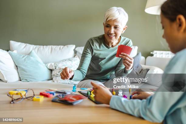 grandmother and grandmother playing board games at home - game night leisure activity stock pictures, royalty-free photos & images