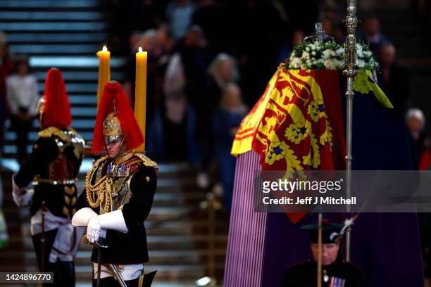 Household Cavalry, Blues and Royals stand guard where Queen Elizabeth II's flag-draped coffin is lying in state on the catafalque at Westminster Hall...