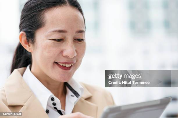 life-changing business opportunities in entrepreneurship. portrait of a japanese entrepreneur standing and using a tablet computer outside a modern business office. - hybrid cloud stock pictures, royalty-free photos & images