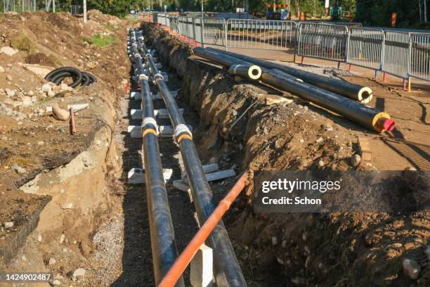 work on laying pipes for district heating in the ground - district heating plant stock pictures, royalty-free photos & images