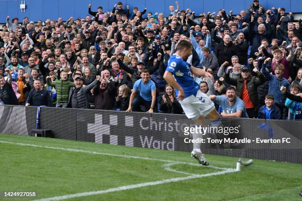 Everton fans celebrate as Neal Maupay celebrate the goal by kicking the corner flag during the Premier League match between Everton and West Ham...